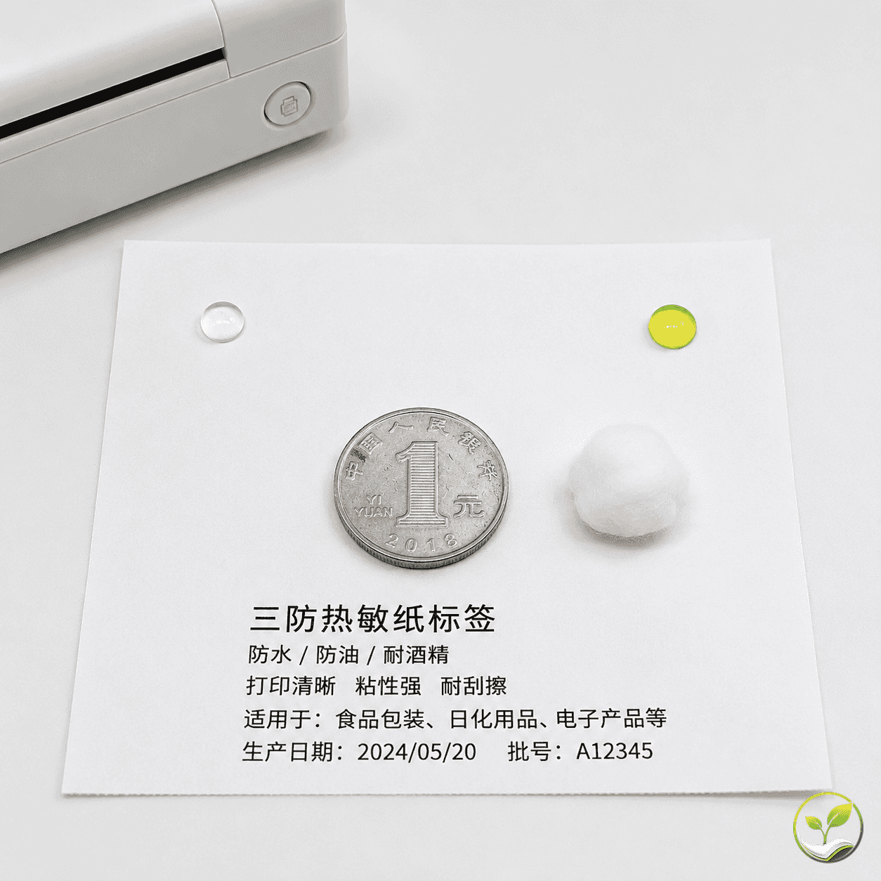 一张热敏纸标签平铺在白色台面上，纸面左侧滴有清水水珠，右侧滴有食用油，中间放一枚硬币，旁边有一块沾了酒精的棉花，远处有一台热敏打印机刚打印出的样条，展示五项指标的简易测试方法